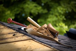 Roofing tools placed on top of a roof, emphasizing the importance of roof inspections during summer for maintenance and safety.