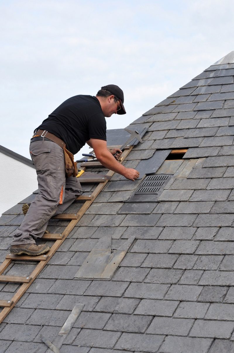 Roof repair image showing a man fixing the roof
